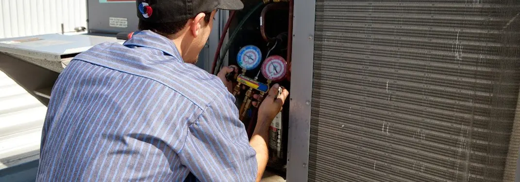 HVAC technician servicing a condenser unit in Streator