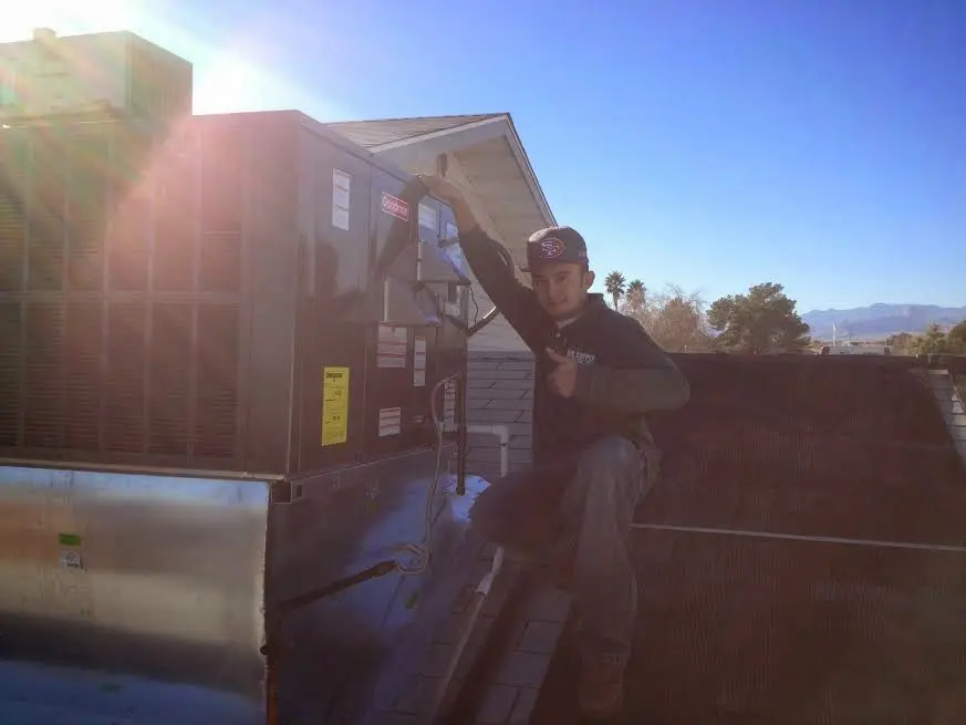 HVAC technician performing AC Tune-Up on a rooftop unit in Streator